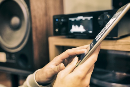 Woman listening to music and controlling max2play audioplayer via tablet